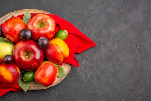 Draufsicht frische Äpfel mit Pfirsichen und Pflaumen auf dem dunklen Tisch reifen Obstbaumsaft