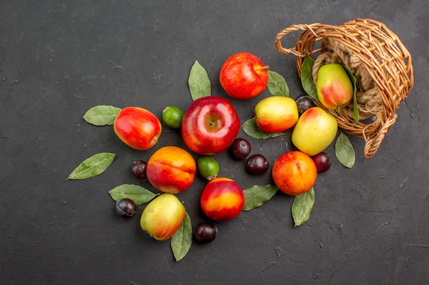 Draufsicht frische Äpfel mit Pflaumen und Pfirsichen auf dunklem Tisch reifen Saft reif