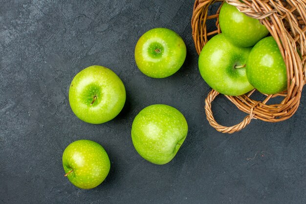 Draufsicht frische Äpfel verstreut vom Weidenkorb auf dunkler Oberfläche