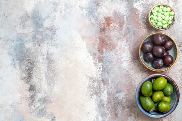 Draufsicht frische Pflaumen mit Feijoas und Süßigkeiten