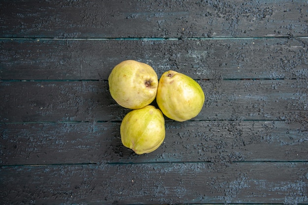 Draufsicht frische Quitten milde und saure Früchte auf dem dunkelblauen Schreibtisch reife Fötus frische Baumsauerpflanze