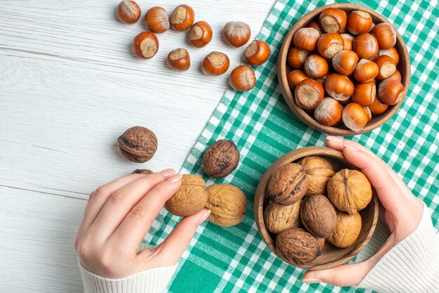 Draufsicht frische rohe Haselnüsse mit Walnüssen auf weißem Tisch-Snack-Pflanzenfutter-Nuss-Pistazien