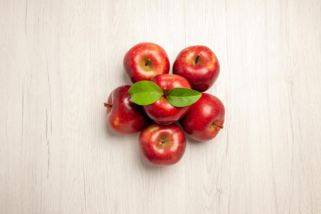 Draufsicht frische rote äpfel ausgereifte und reife früchte auf weißem schreibtischfruchtfarbe frischer pflanzenrotbaum