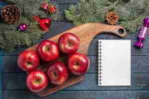 Kostenloses Foto draufsicht frische rote äpfel milde reife früchte auf dunkelblauem schreibtisch pflanzen viele fruchtfarben frisches vitaminrot