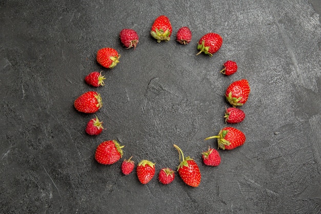 Draufsicht frische rote Erdbeeren gezeichnet auf dunkelgrauer Tischfarbe Beerenfrucht