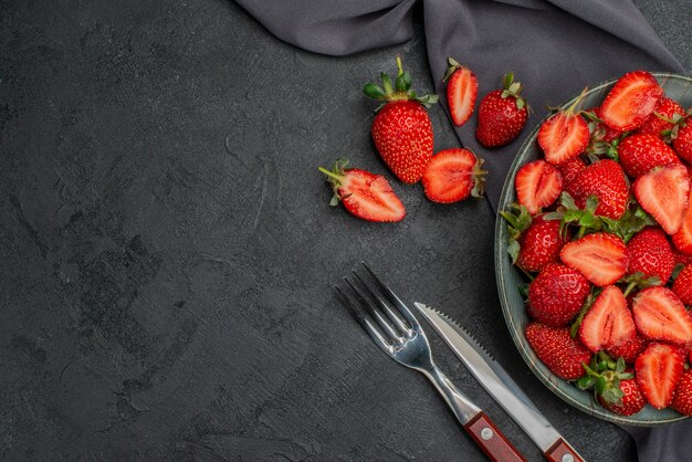 Draufsicht frische rote Erdbeeren innerhalb des Tellers auf dunklem Hintergrund