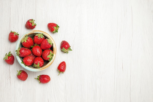 Draufsicht frische rote Erdbeeren innerhalb Platte auf weißem Schreibtisch