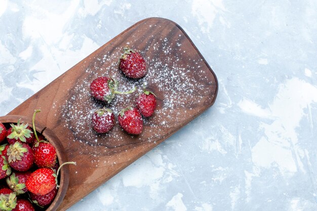 Draufsicht frische rote Erdbeeren reife Beeren auf dem hellen Schreibtisch