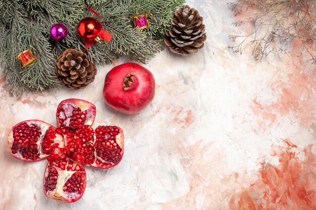 Draufsicht frische rote Granatäpfel mit Baum und Spielzeug auf hellem Hintergrund