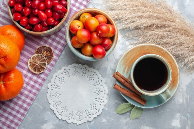 Draufsicht frische rote Hartriegel mit Tee auf hellem Schreibtischfrucht frischer Tee weich reif