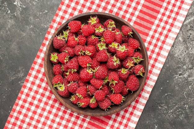 Kostenloses Foto draufsicht frische rote himbeeren im teller auf grauem hintergrund