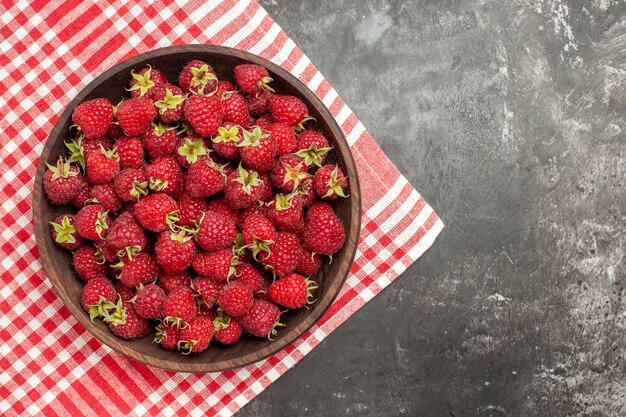 Draufsicht frische rote Himbeeren im Teller auf grauem Hintergrund