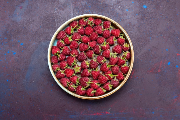 Draufsicht frische rote Himbeeren reife Beeren auf dunkelblauem Hintergrundfrucht mildes Sommerlebensmittelvitamin