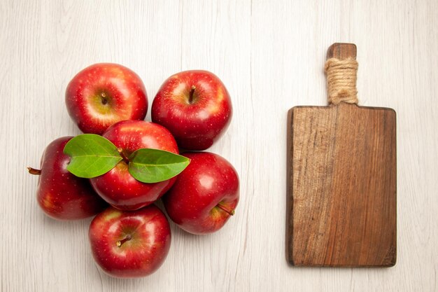 Draufsicht frische rote Äpfel ausgereifte und reife Früchte auf weißem Schreibtisch Pflanzenfruchtfarbe frischer roter Baum