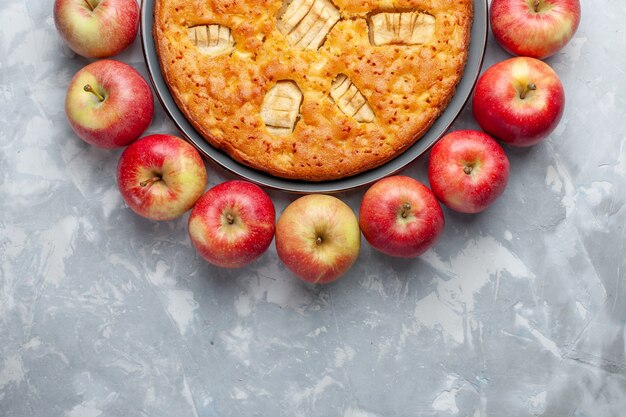 Draufsicht frische rote Äpfel bilden Kreis mit Apfelkuchen auf dem hellen Schreibtischfrucht frisches weiches reifes Vitamin