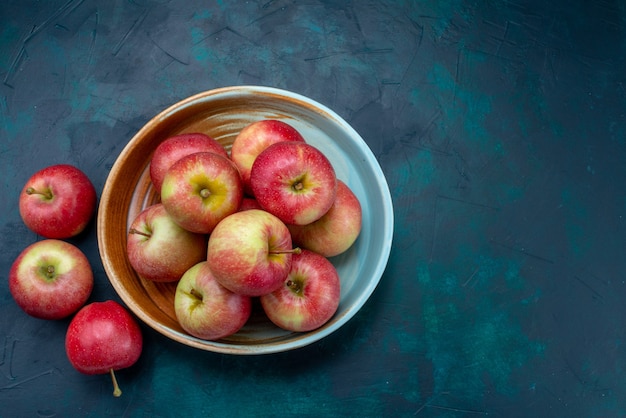 Draufsicht frische rote Äpfel saftig und weich auf dem dunkelblauen Hintergrundfrucht frisches reifes mildes Vitamin