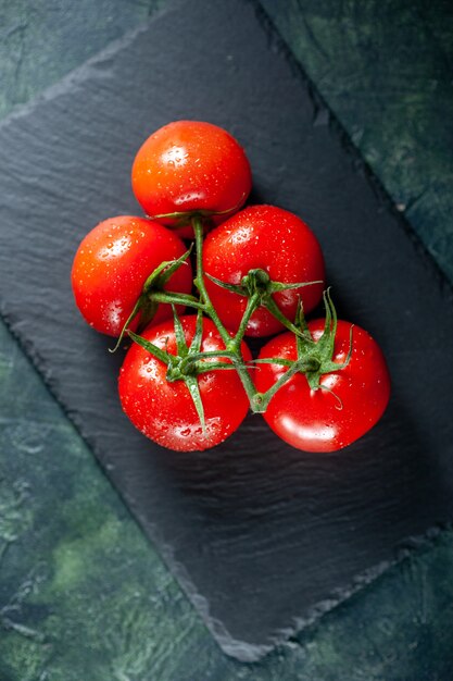 Draufsicht frische rote Tomaten auf dunkler Oberfläche wachsen Mahlzeit Essen Abendessen Baum reifen Farbsalat Foto