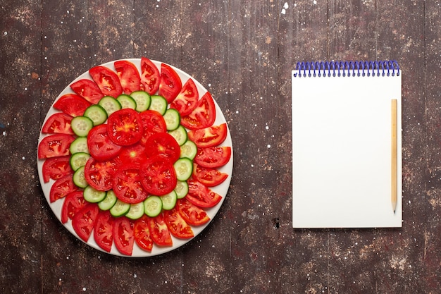 Kostenloses Foto draufsicht frische rote tomaten geschnittenen frischen salat auf braunem schreibtisch