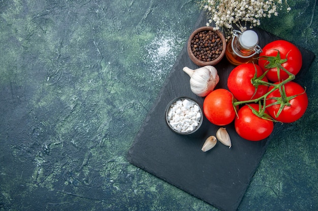 Draufsicht frische rote Tomaten mit Gewürzen auf dunklem Hintergrund