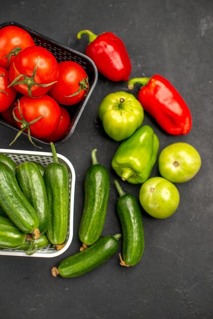 Draufsicht frische rote Tomaten mit Gurken auf dunklem Hintergrund