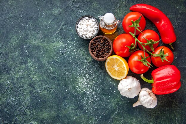 Draufsicht frische rote Tomaten mit Knoblauch und Paprika auf dunklem Hintergrund Salat reifen Gesundheitsdiät Lebensmittel Mahlzeit freien Raum