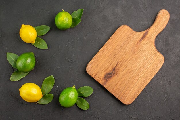 Draufsicht frische saure Zitronen auf dem dunklen Tischfrucht-Limetten-Zitrus