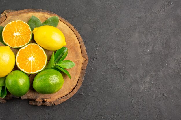 Draufsicht frische saure Zitronen auf dem dunklen Tischfruchtzitruslimette
