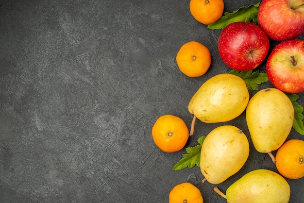 Draufsicht frische süße Birnen mit Mandarinen und Äpfeln auf grauem Hintergrund