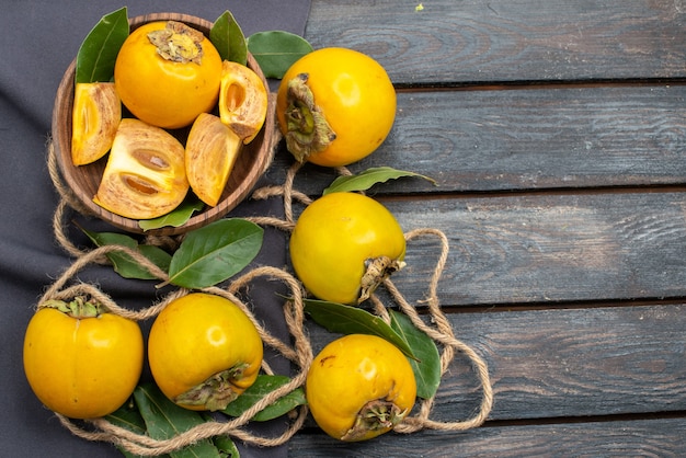 Draufsicht frische süße Kakis auf dem hölzernen rustikalen Tisch, reife Frucht