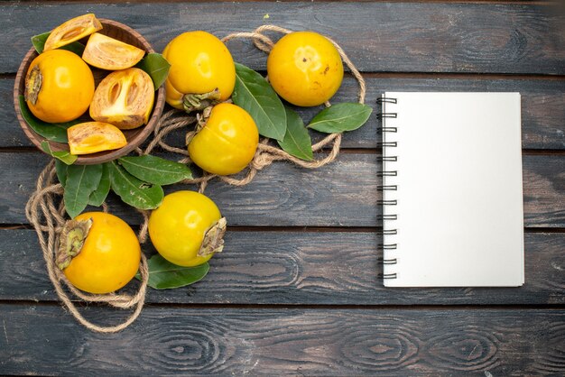 Draufsicht frische süße Kakis auf einem Holztisch, Frucht reifer Geschmack