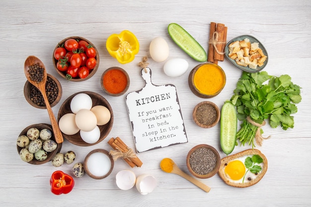 Draufsicht frische weiße Eier mit Gemüse und Gewürzen auf weißem Hintergrund Lebensmittelfarbe reifes Mittagessen Salatfrühstück