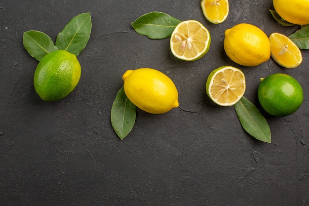 Draufsicht frische Zitronen saure Früchte auf dunklem Boden Zitrus Limettenfrucht