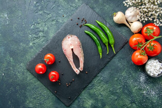 Draufsicht frischer Fisch Scheibe mit Tomaten und grünem Pfeffer auf dunklem Hintergrund Meeresfrüchte Ozeanfleisch Meeresmehl Wasser Pfeffer Pfeffer Gericht Essen