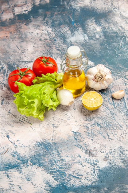 Draufsicht frischer grüner Salat mit Öl und Tomaten auf hellblauem Hintergrund