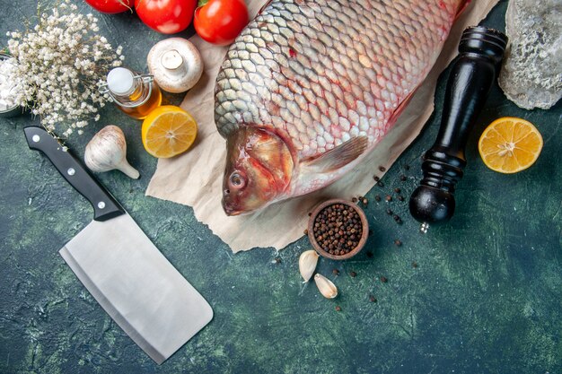 Draufsicht frischer roher Fisch mit Tomaten und Pilzen auf dunkelblauem Hintergrund