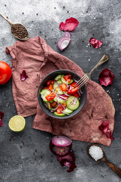 Draufsicht frischer Salat in dunkler Schüssel auf Stoff