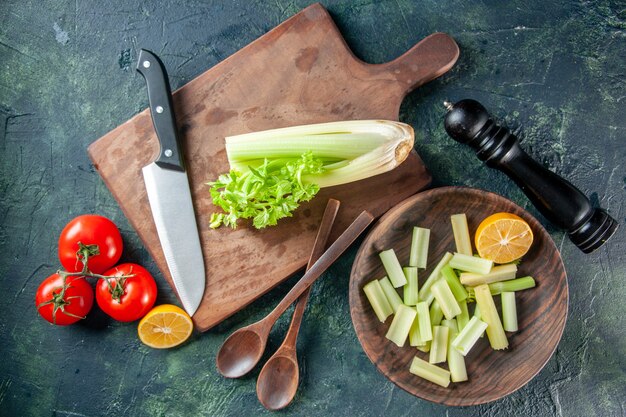 Draufsicht frischer Sellerie mit roten Tomaten auf dunklem Tischsalat-Diätmahlzeitfoto-Nahrungsmittelgesundheitsfarben, die Küche kochen