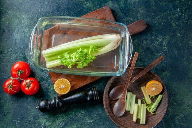 Draufsicht frischer Sellerie mit Tomaten auf dunklem Tischsalatdiätmahlzeitfarbfoto-Nahrungsmittelgesundheit