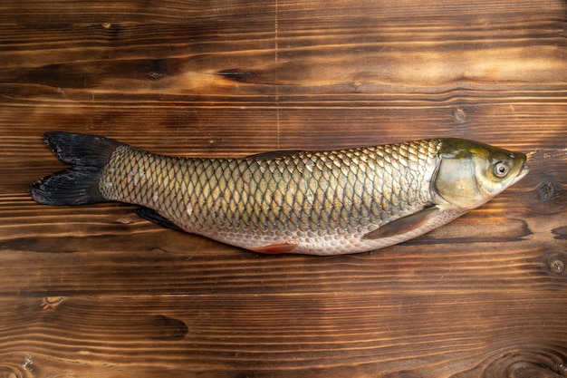 Kostenloses Foto draufsicht frisches fischrohprodukt auf hölzernem tischfischmeeresfleischozeanfutter