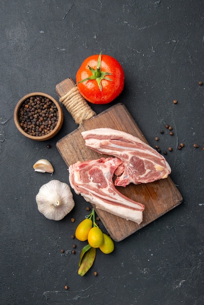 Kostenloses Foto draufsicht frisches fleisch rippen rohes fleisch mit gewürzen auf dunklem grill tiergericht pfeffer küche essen kuhsalat essen