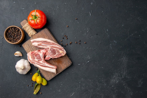 Draufsicht frisches Fleisch Rippen rohes Fleisch mit Gewürzen auf dunklem Grill Tiergericht Pfeffer Küche Essen Kuhsalat Essen