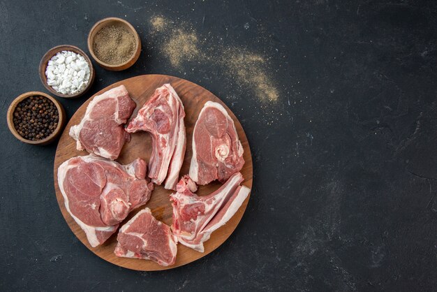 Draufsicht frisches Fleisch schneidet rohes Fleisch auf dunkler Mahlzeit Lebensmittelfrische Kuhfutter Küche Tier