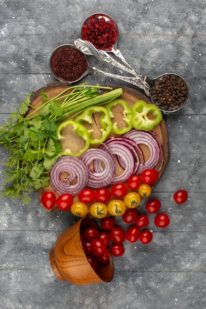 Kostenloses Foto draufsicht frisches gemüse ganz geschnitten wie zwiebeln grün tomaten auf dem grau