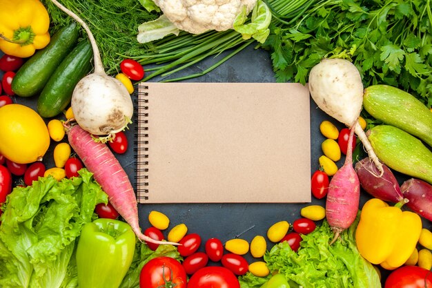 Draufsicht frisches Gemüse Kirschtomaten cumcuat Salatdill gelbe Paprika Gurke Zucchini Notizblock in der Mitte