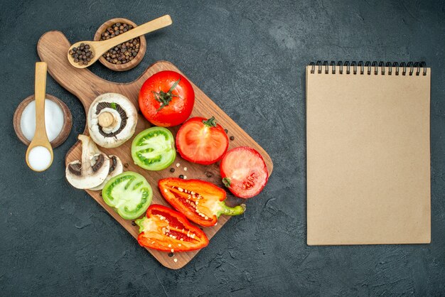 Draufsicht frisches Gemüse Pilze rote und grüne Tomaten Paprika auf Schneidebrett schneiden