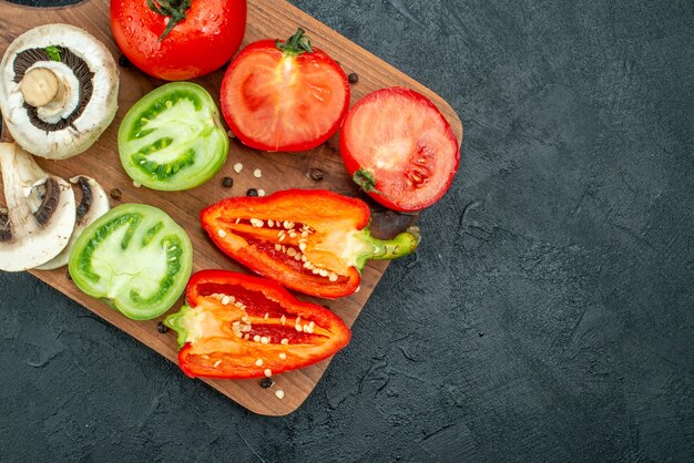 Draufsicht frisches Gemüse Pilze rote und grüne Tomaten Paprika auf Schneidebrett