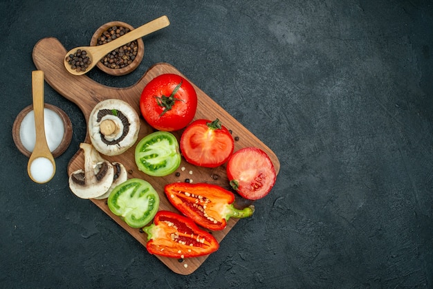 Draufsicht frisches Gemüse Pilze rote und grüne Tomaten Paprika auf Schneidebrett