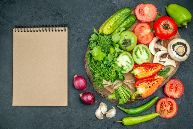 Draufsicht frisches gemüse pilze rote und grüne tomaten rote paprikagrüns auf rustikalem brett