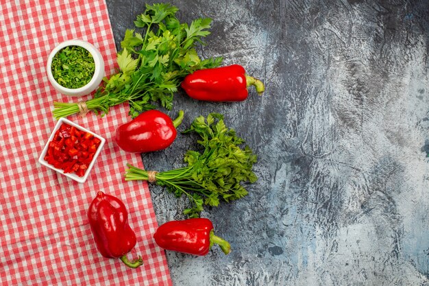 Draufsicht frisches Grün mit roter Paprika auf dem hellgrauen Tisch