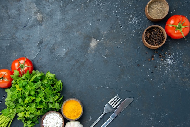 Draufsicht frisches Grün mit Tomaten und Gewürzen auf dem dunklen Tisch